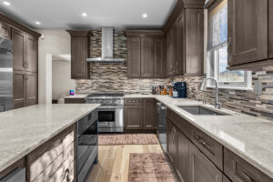 Maple cabinetry. Island featuring wainscot panels and built-in drawer microwave.